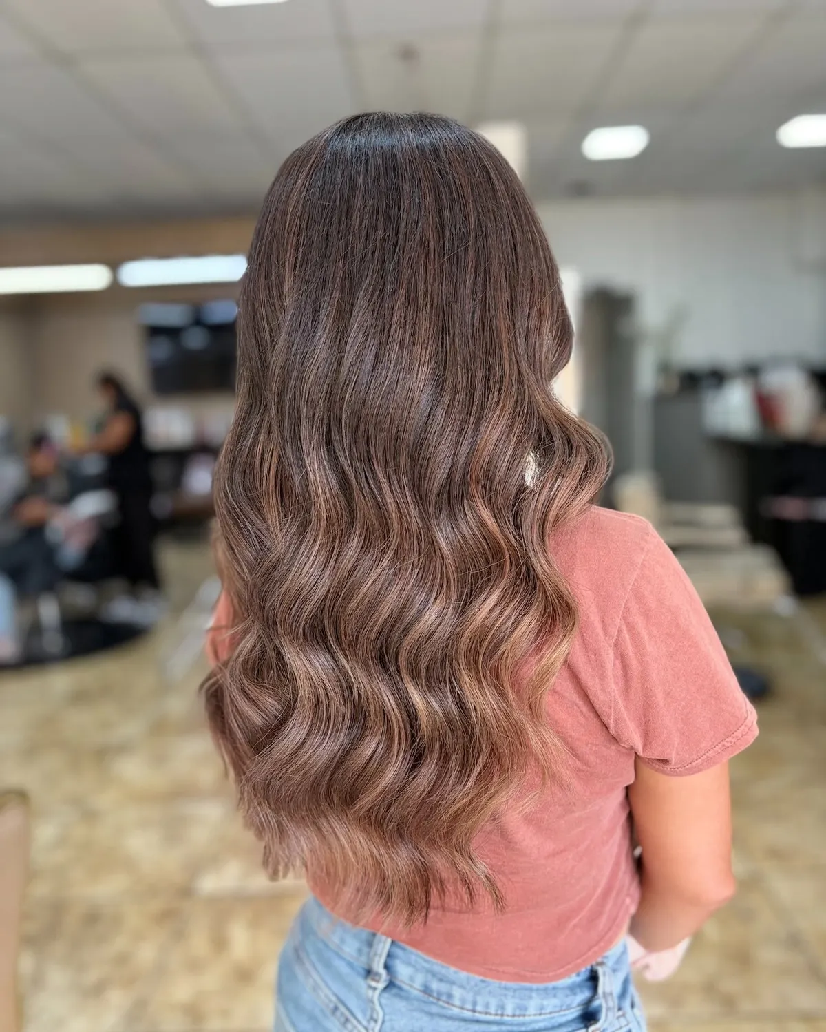 Cabello largo con balayage chocolate y ondas suaves, hecho en Vanguardia