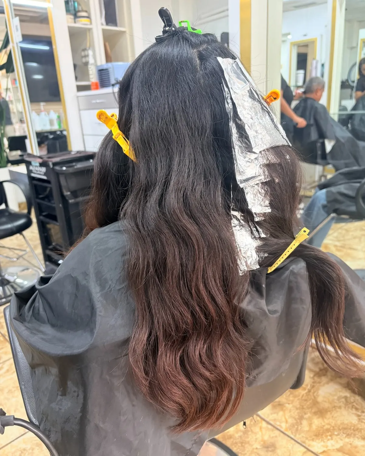 Colorista aplicando aluminio para un efecto de color en el salón